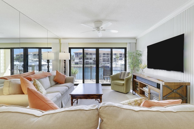 living room featuring plenty of natural light, ornamental molding, ceiling fan, and a textured ceiling