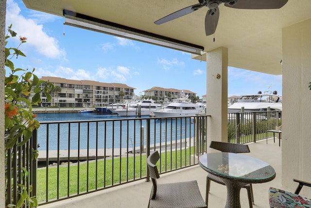 balcony featuring a water view and a ceiling fan