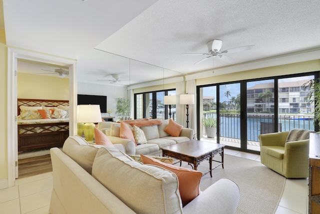 living room featuring a ceiling fan, light tile patterned floors, and a textured ceiling