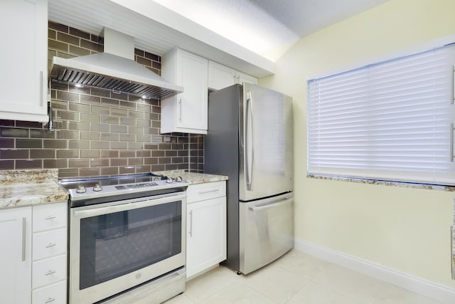 kitchen featuring appliances with stainless steel finishes, wall chimney exhaust hood, tasteful backsplash, and white cabinets
