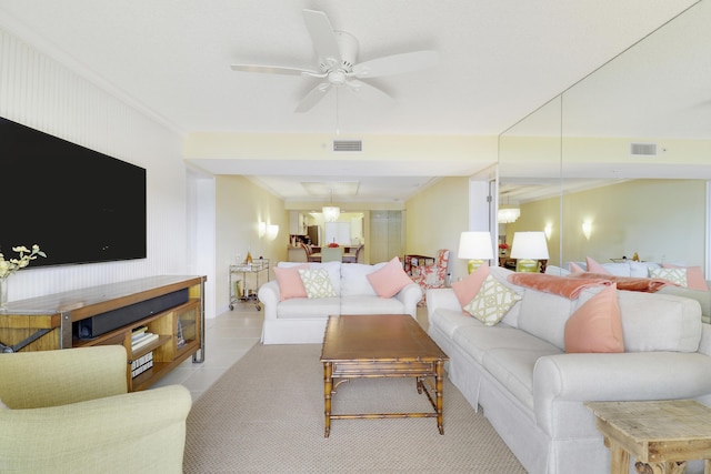 living area featuring ceiling fan, crown molding, and light tile patterned floors