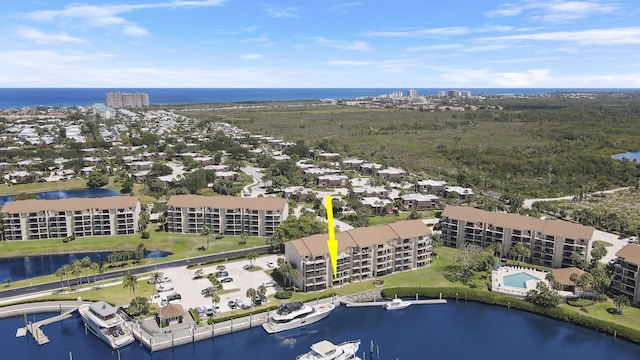 drone / aerial view of a nearby body of water and apartment complex / building