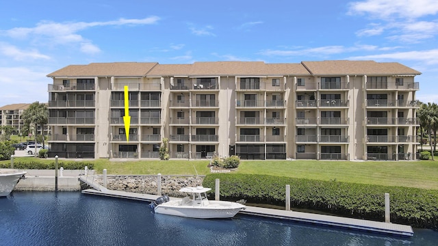 view of swimming pool featuring a yard, a dock, and a water view