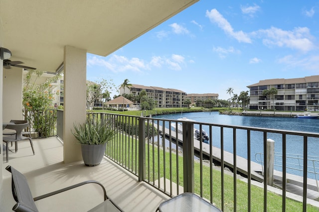 balcony with a water view and a ceiling fan