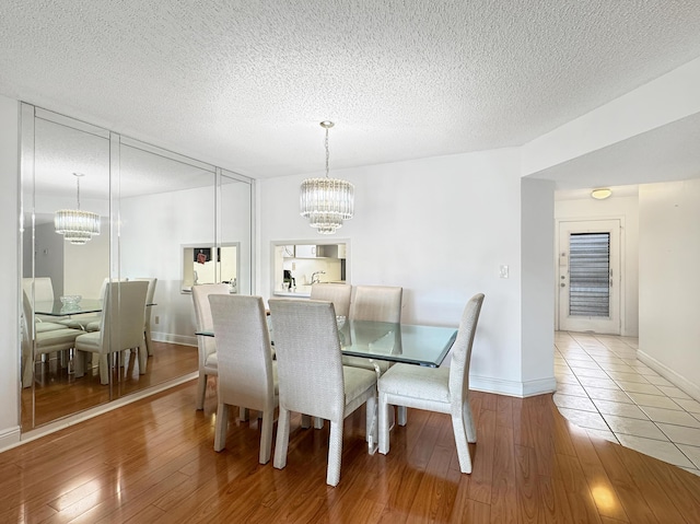 4960 E Sabal Palm Blvd Unit 206, Tamarac, FL 33319 - dining area featuring a chandelier, wood finished floors, baseboards, and a textured ceiling