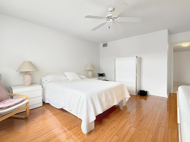 4960 E Sabal Palm Blvd Unit 206, Tamarac, FL 33319 - bedroom featuring light wood-type flooring, a textured ceiling, and a ceiling fan