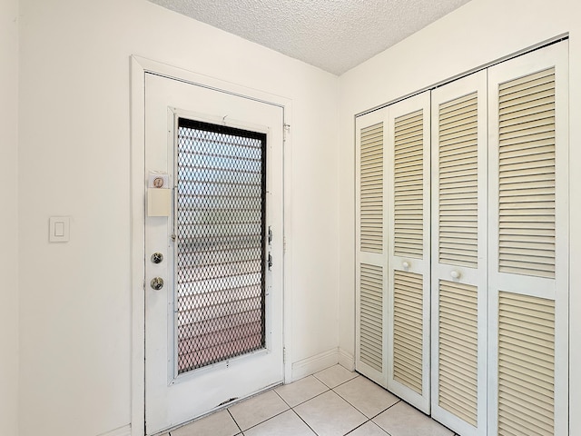 4960 E Sabal Palm Blvd Unit 206, Tamarac, FL 33319 - doorway to outside with light tile patterned floors, a textured ceiling, and baseboards