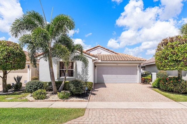 7338 Chorale Rd, Boynton Beach, FL 33437 - mediterranean / spanish home with stucco siding, an attached garage, driveway, and a tile roof