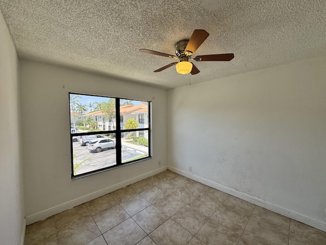 1453 Lake Crystal Dr Unit H, West Palm Beach, FL 33411 - unfurnished room featuring a textured ceiling, a ceiling fan, baseboards, and light tile patterned flooring