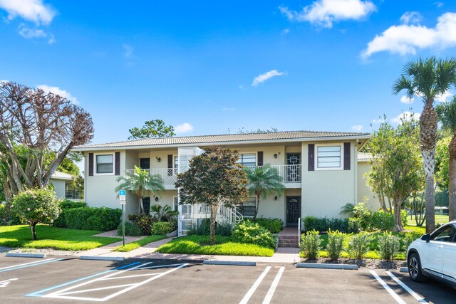 6 Stratford Dr E Unit D, Boynton Beach, FL 33436 - view of property featuring uncovered parking and stairs