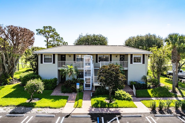 6 Stratford Dr E Unit D, Boynton Beach, FL 33436 - view of front of property featuring stucco siding, uncovered parking, stairway, and a tiled roof