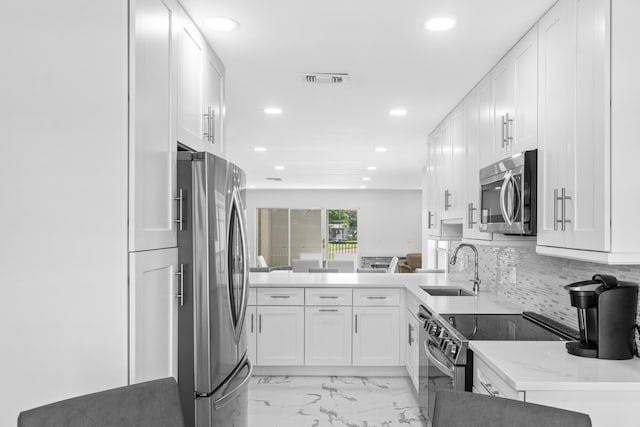6 Stratford Dr E Unit D, Boynton Beach, FL 33436 - kitchen with stainless steel appliances, a sink, recessed lighting, white cabinetry, and tasteful backsplash