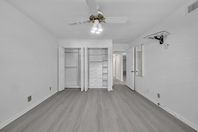 15244 Lakes Of Delray Blvd Unit 112, Delray Beach, FL 33484 - unfurnished bedroom with wood finished floors, baseboards, a textured ceiling, multiple closets, and ceiling fan