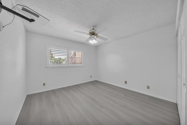 15244 Lakes Of Delray Blvd Unit 112, Delray Beach, FL 33484 - spare room featuring a textured ceiling, wood finished floors, a ceiling fan, and baseboards