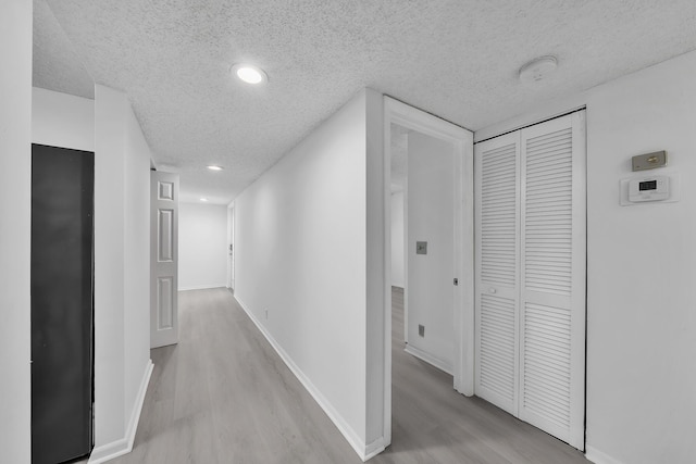 15244 Lakes Of Delray Blvd Unit 112, Delray Beach, FL 33484 - hallway featuring a textured ceiling, light wood-type flooring, baseboards, and recessed lighting