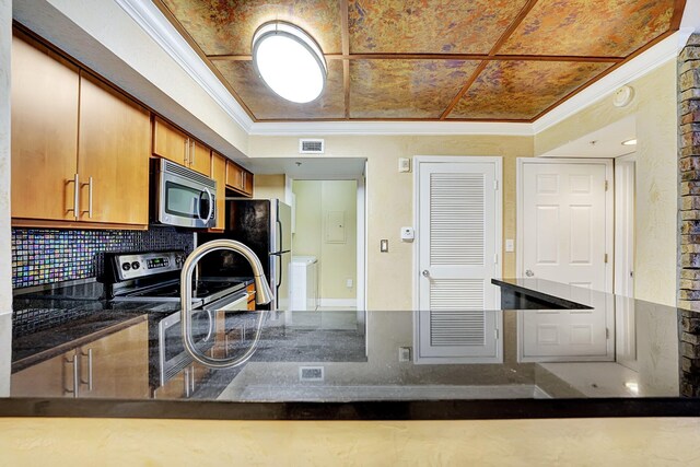 15035 Michelangelo Blvd Unit 106, Delray Beach, FL 33446 - kitchen with appliances with stainless steel finishes, ornamental molding, backsplash, dark countertops, and a peninsula
