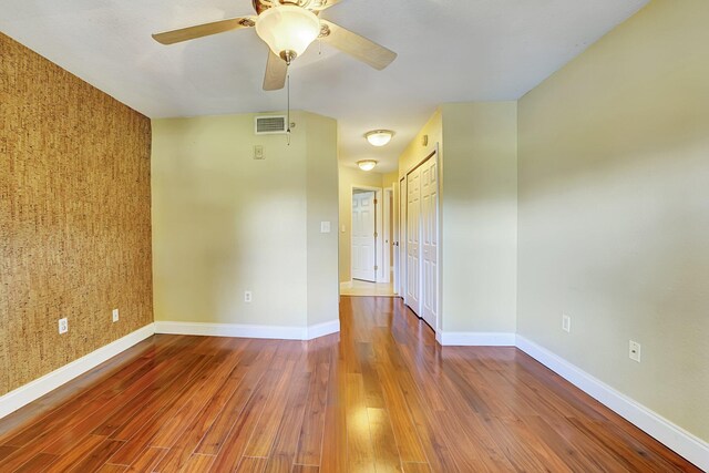 15035 Michelangelo Blvd Unit 106, Delray Beach, FL 33446 - spare room featuring wood finished floors, a ceiling fan, baseboards, and an accent wall