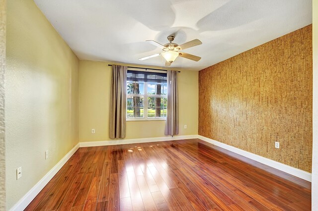 15035 Michelangelo Blvd Unit 106, Delray Beach, FL 33446 - empty room featuring wood-type flooring, ceiling fan, and baseboards