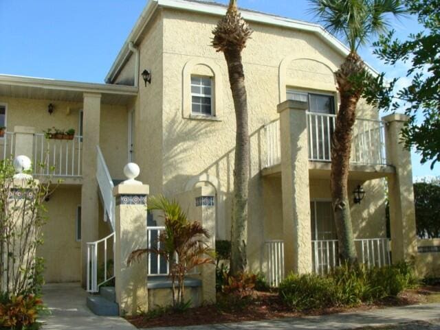 1604 SE Green Acres Cir Unit T201, Port Saint Lucie, FL 34952 - view of front of property with a balcony, stucco siding, and a porch
