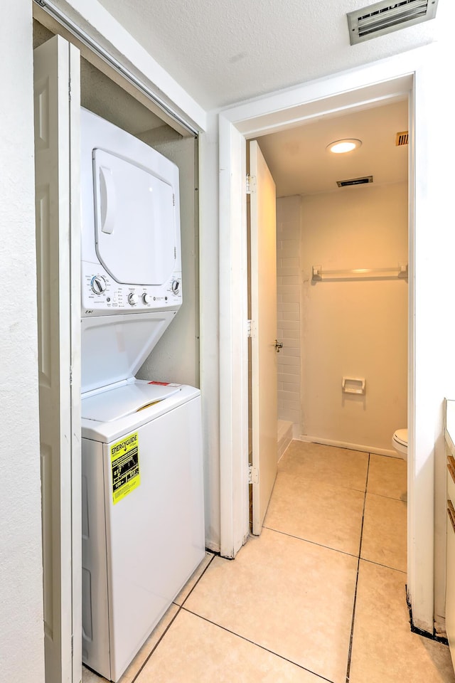 1604 SE Green Acres Cir Unit T201, Port Saint Lucie, FL 34952 - washroom featuring stacked washer / drying machine and light tile patterned flooring