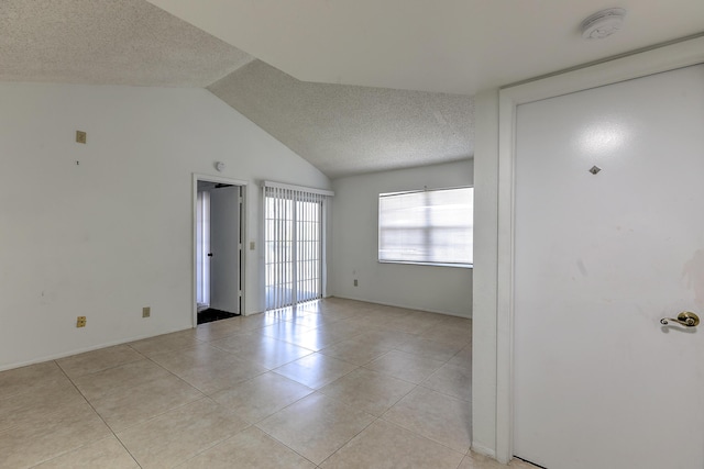 1604 SE Green Acres Cir Unit T201, Port Saint Lucie, FL 34952 - unfurnished room featuring a textured ceiling, light tile patterned flooring, a smoke detector, and vaulted ceiling