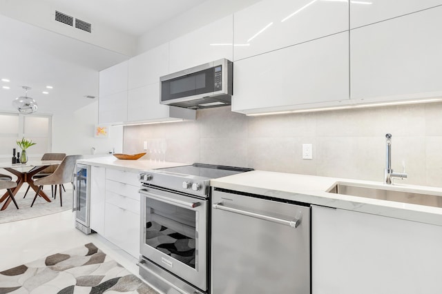 2780 S Ocean Blvd Unit 311, Palm Beach, FL 33480 - kitchen with stainless steel appliances, a sink, beverage cooler, and modern cabinets