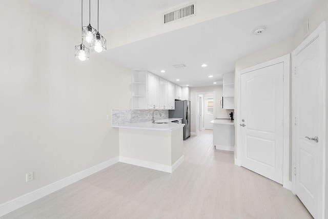 122 Ashley Ct, Jupiter, FL 33458 - kitchen with open shelves, a sink, white cabinets, light wood-style flooring, and recessed lighting