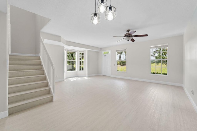 122 Ashley Ct, Jupiter, FL 33458 - unfurnished living room featuring a ceiling fan, stairway, light wood-style floors, and baseboards