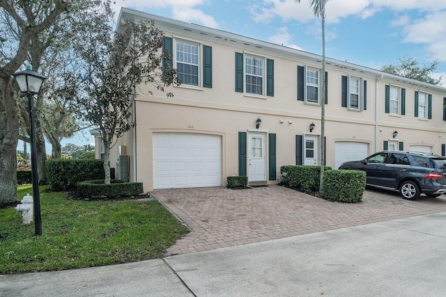 122 Ashley Ct, Jupiter, FL 33458 - multi unit property featuring driveway, a garage, stucco siding, and a front lawn