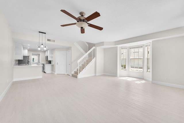 122 Ashley Ct, Jupiter, FL 33458 - unfurnished living room with stairs, light wood-style floors, ceiling fan, and baseboards