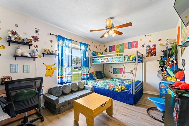 2389 SW Caballero St, Port Saint Lucie, FL 34953 - bedroom with wood finished floors, a textured ceiling, baseboards, and ceiling fan