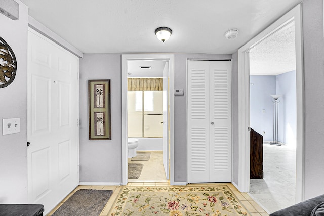 1673 SE Green Acres Cir Unit Nn-202, Port Saint Lucie, FL 34952 - foyer with light tile patterned flooring, a textured ceiling, and baseboards
