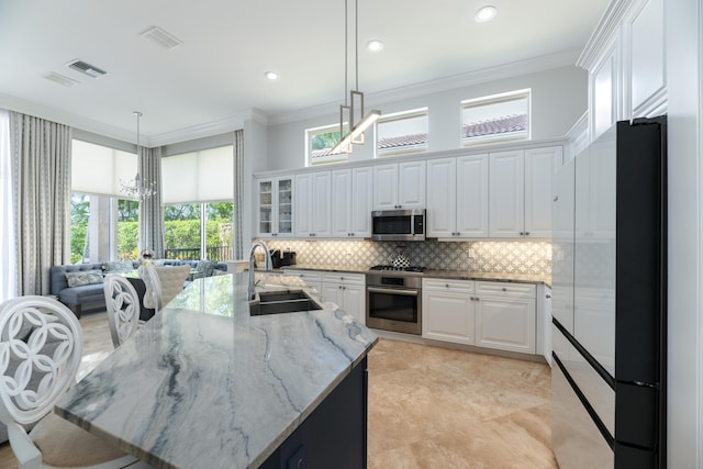 157 Esperanza Way, Palm Beach Gardens, FL 33418 - kitchen with appliances with stainless steel finishes, a sink, backsplash, ornamental molding, and white cabinetry