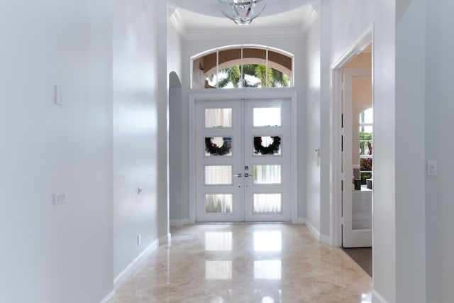 157 Esperanza Way, Palm Beach Gardens, FL 33418 - foyer entrance featuring ornamental molding, french doors, marble tiled flooring, a towering ceiling, and baseboards