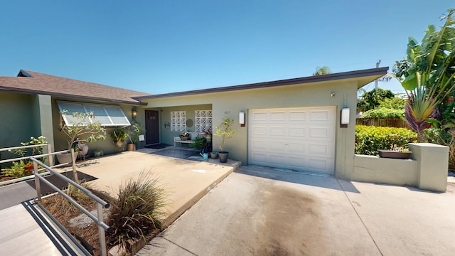 ranch-style home featuring stucco siding, concrete driveway, a garage, and fence