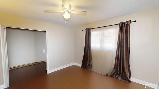 unfurnished room with a ceiling fan, wood finished floors, and baseboards