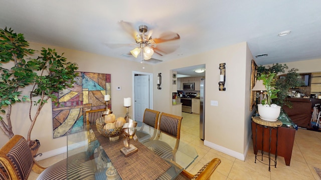 dining room with light tile patterned floors, a ceiling fan, and baseboards