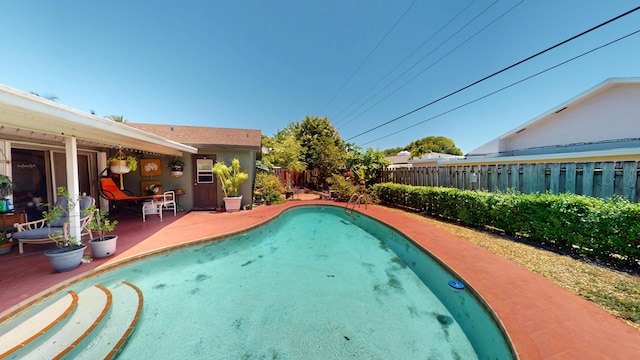 view of pool with a fenced backyard and a patio