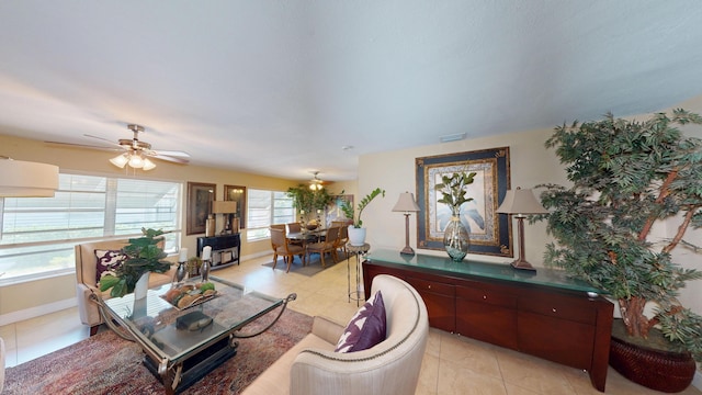 living room with light tile patterned flooring, ceiling fan, and baseboards