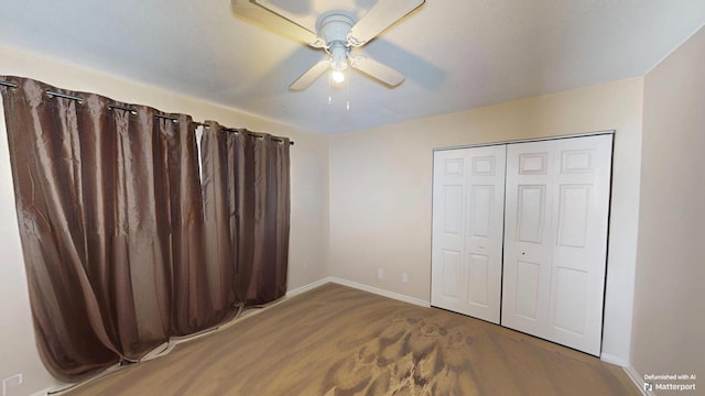 unfurnished bedroom with baseboards, ceiling fan, and a closet