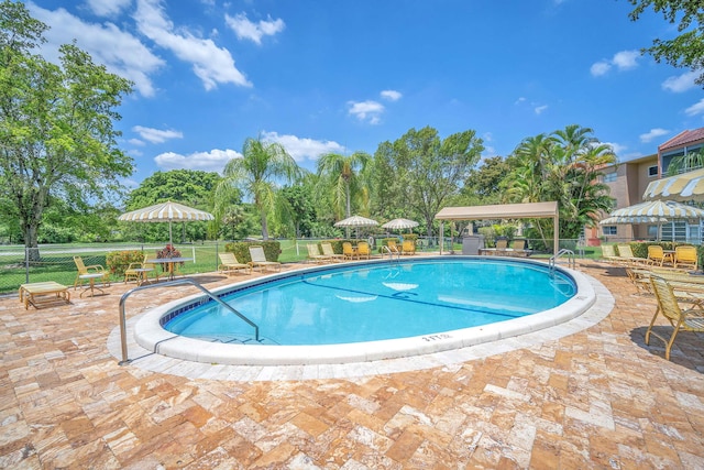 8826 W Mcnab Rd Unit 201, Tamarac, FL 33321 - community pool with fence, a patio area, and view of scattered trees