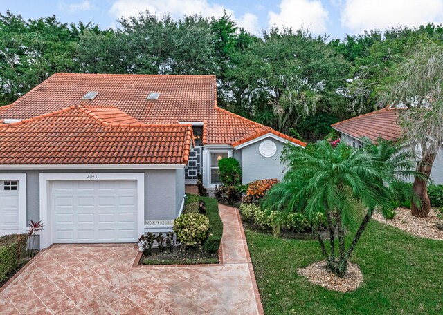 7043 Summer Tree Dr, Boynton Beach, FL 33437 - view of front facade featuring stucco siding, concrete driveway, a tiled roof, and a garage
