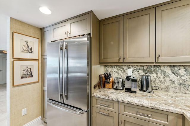 1200 S Flagler Dr Unit 1402, West Palm Beach, FL 33401 - kitchen with freestanding refrigerator, tasteful backsplash, and light stone countertops