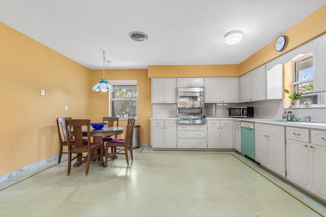 1101 SE 7th Ct, Deerfield Beach, FL 33441 - kitchen featuring dishwashing machine, light countertops, stainless steel microwave, hanging light fixtures, and white cabinets