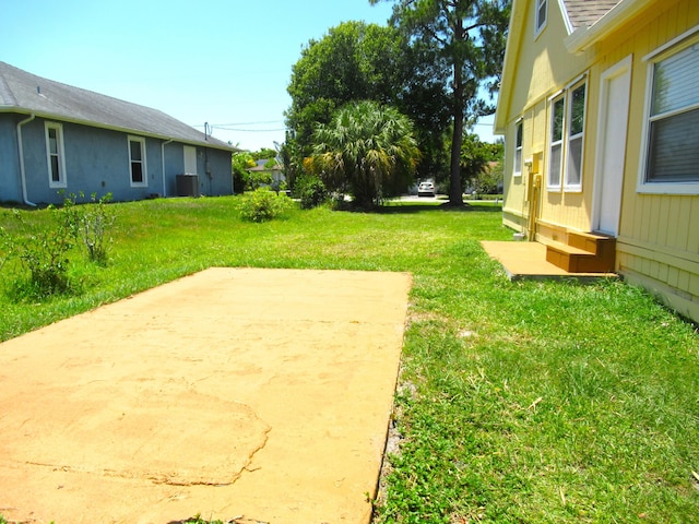 5310 Palm Dr, Fort Pierce, FL 34982 - view of green lawn featuring a patio area and central air condition unit