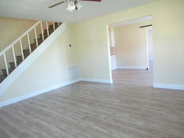 5310 Palm Dr, Fort Pierce, FL 34982 - unfurnished living room with a ceiling fan, stairway, wood finished floors, and baseboards