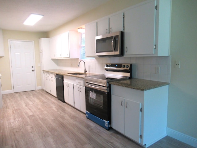 5310 Palm Dr, Fort Pierce, FL 34982 - kitchen featuring appliances with stainless steel finishes, a sink, decorative backsplash, and light wood-style floors