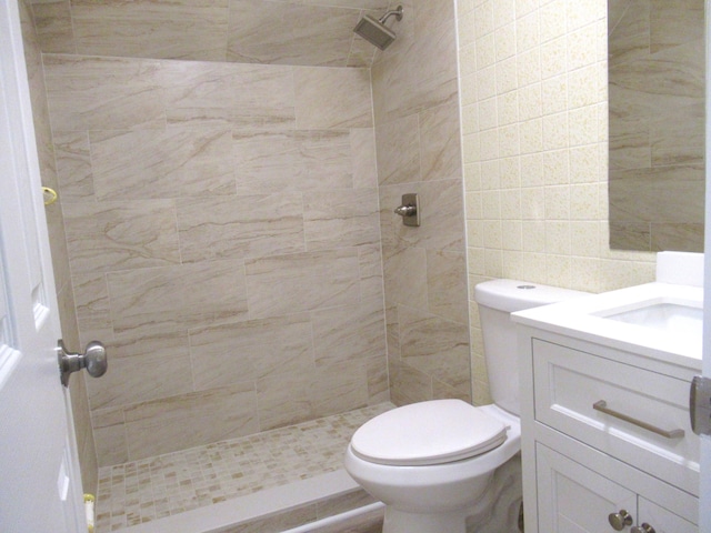 5310 Palm Dr, Fort Pierce, FL 34982 - full bathroom featuring a tile shower, toilet, vanity, and tile walls
