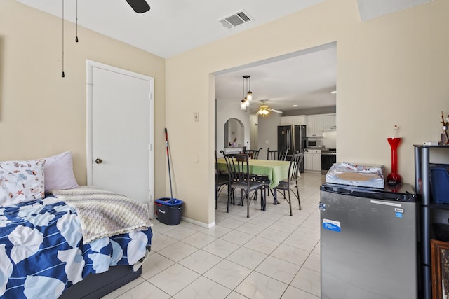 2008 SE Triumph Rd, Port Saint Lucie, FL 34952 - bedroom featuring freestanding refrigerator, fridge, arched walkways, light tile patterned flooring, and baseboards