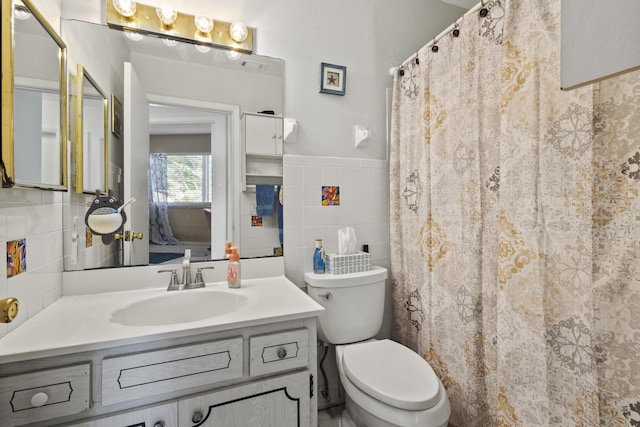 2008 SE Triumph Rd, Port Saint Lucie, FL 34952 - full bathroom featuring tile walls, toilet, vanity, and wainscoting